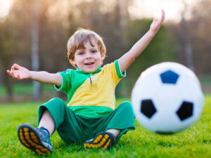 Criança brincando de futebol